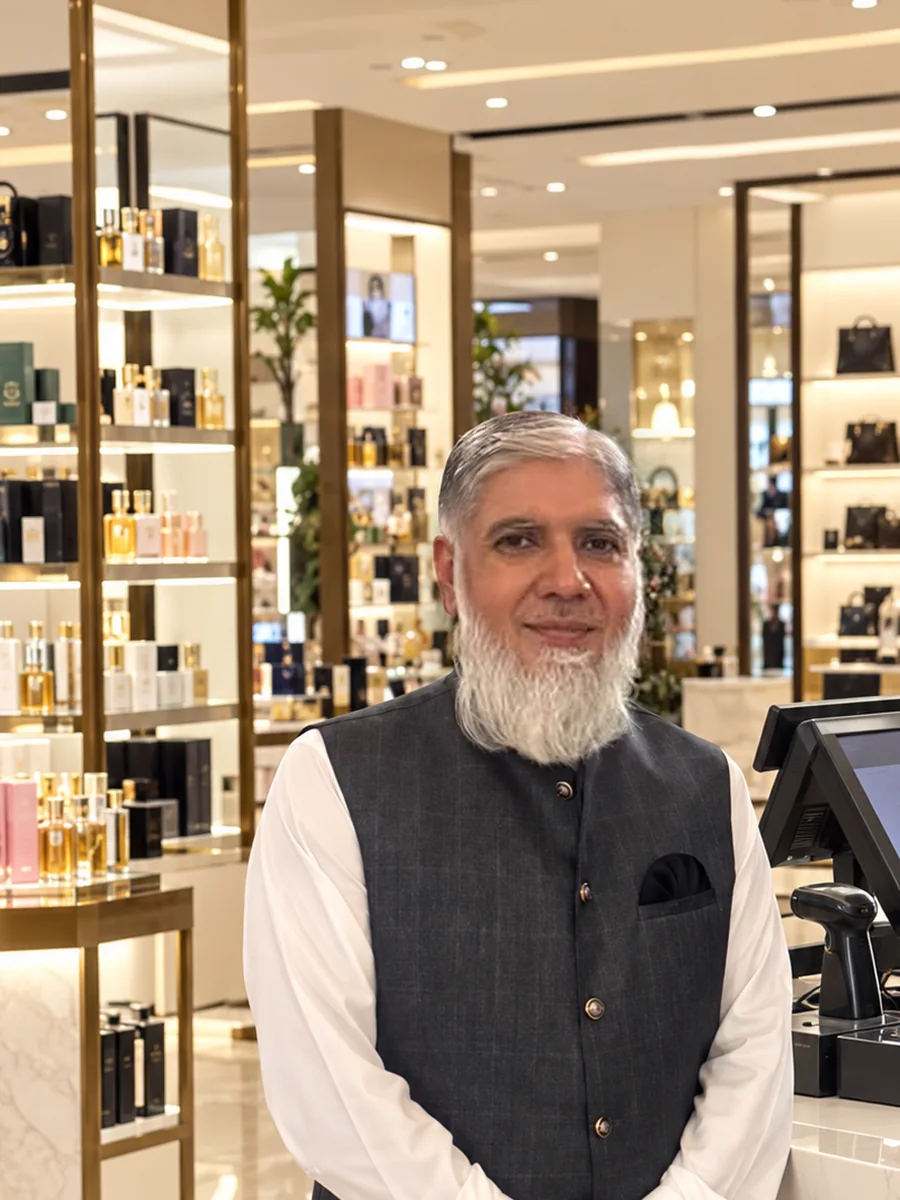 Tuyyab Bukhari beside a POS checkout counter in a modern department store